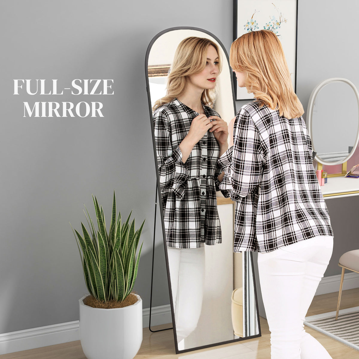 Full-length mirror with rounded top, black frame and freestanding rear support.