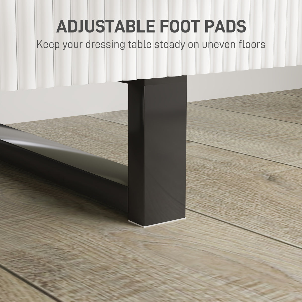 Close-up of a black vanity desk leg with an adjustable foot pad.