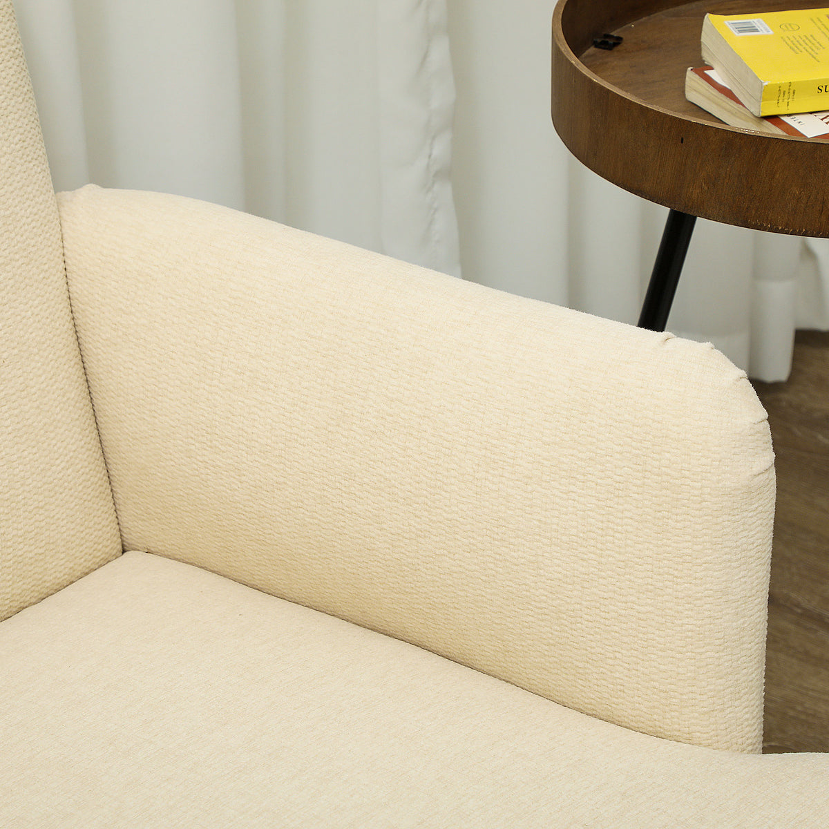 Close-up of the cream loveseat's textured fabric armrest and seat