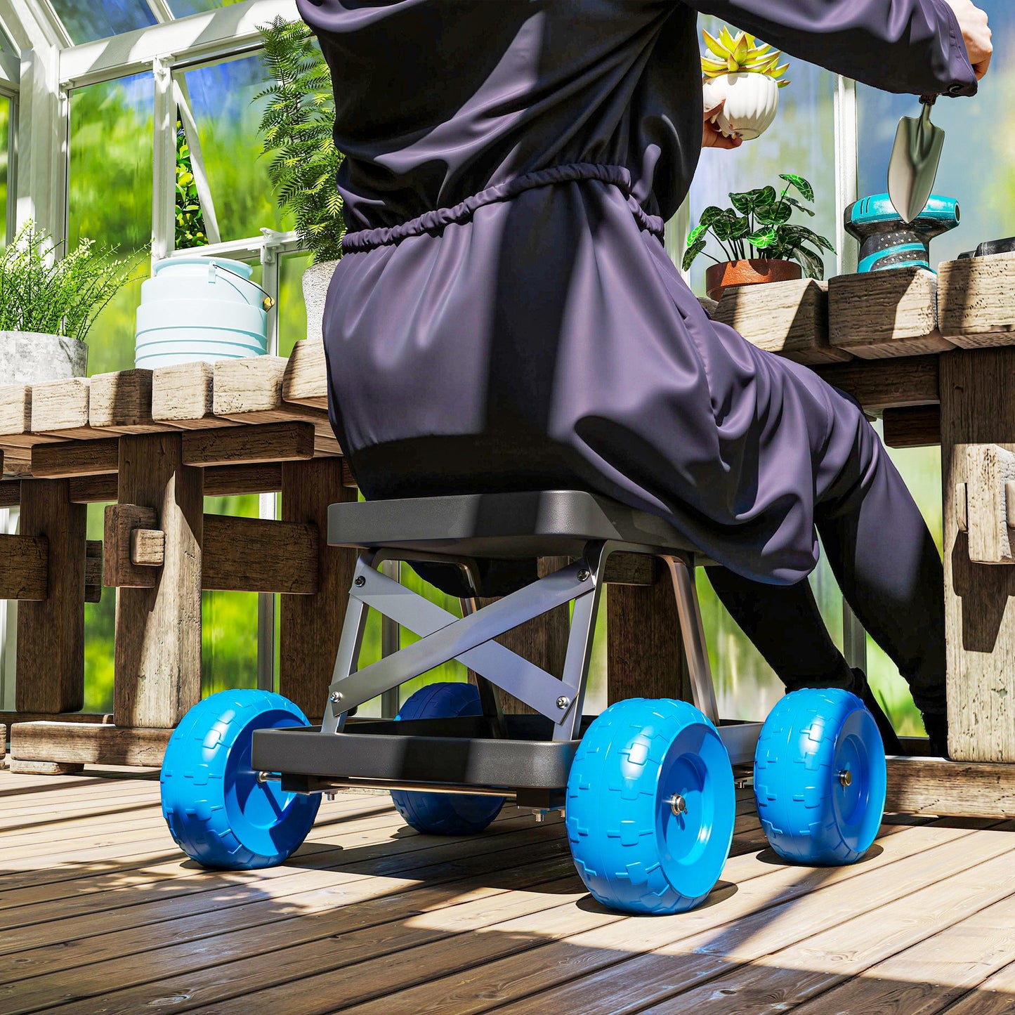 Garden cart with a top seat and wide blue wheels, supporting a seated gardener