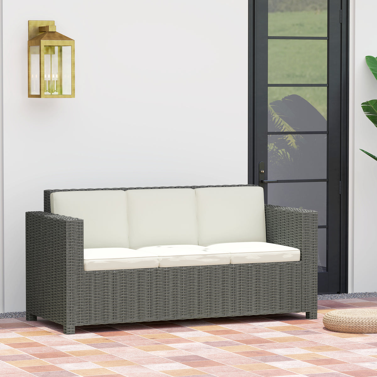 Three-seat dark gray wicker sofa with cream cushions in an indoor setting