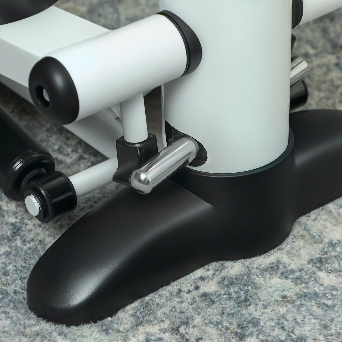 Close-up of the mini stepper's white frame, metal linkage, and black base