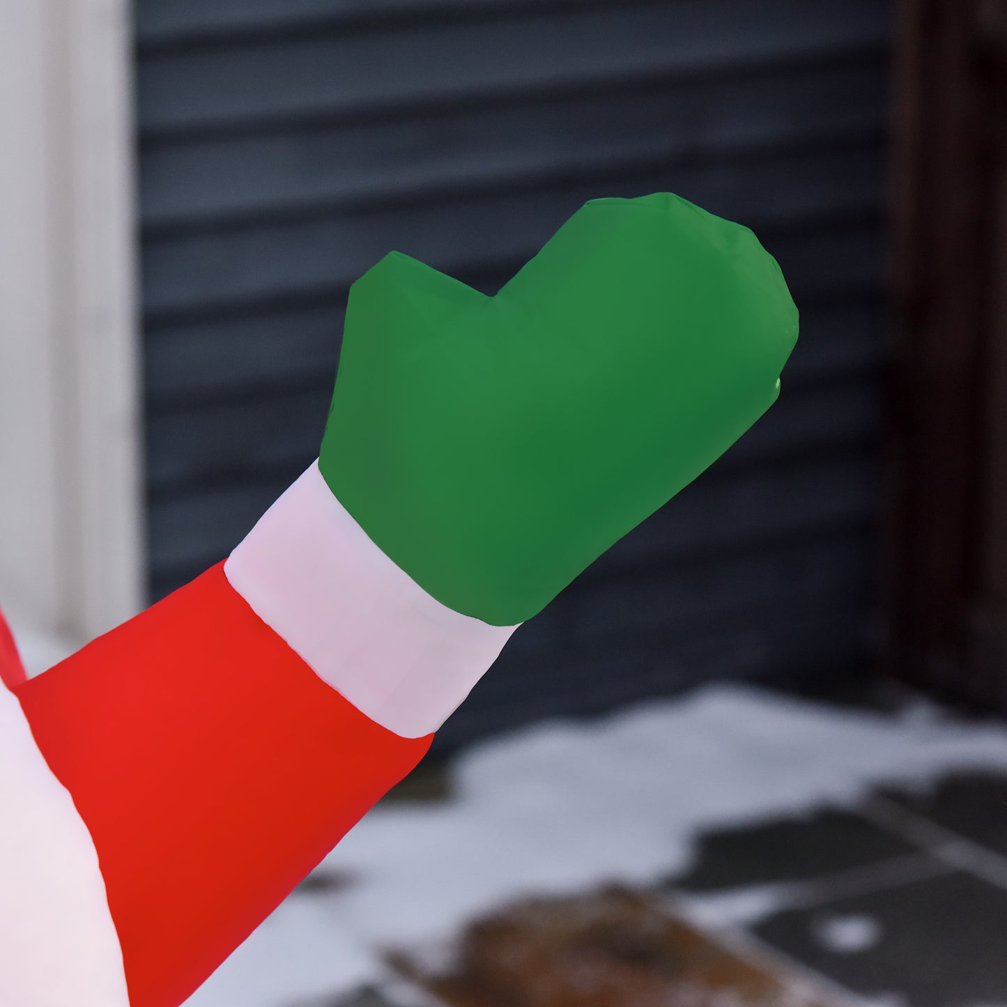 Inflatable Santa figure detail showing a green mitten and red sleeve