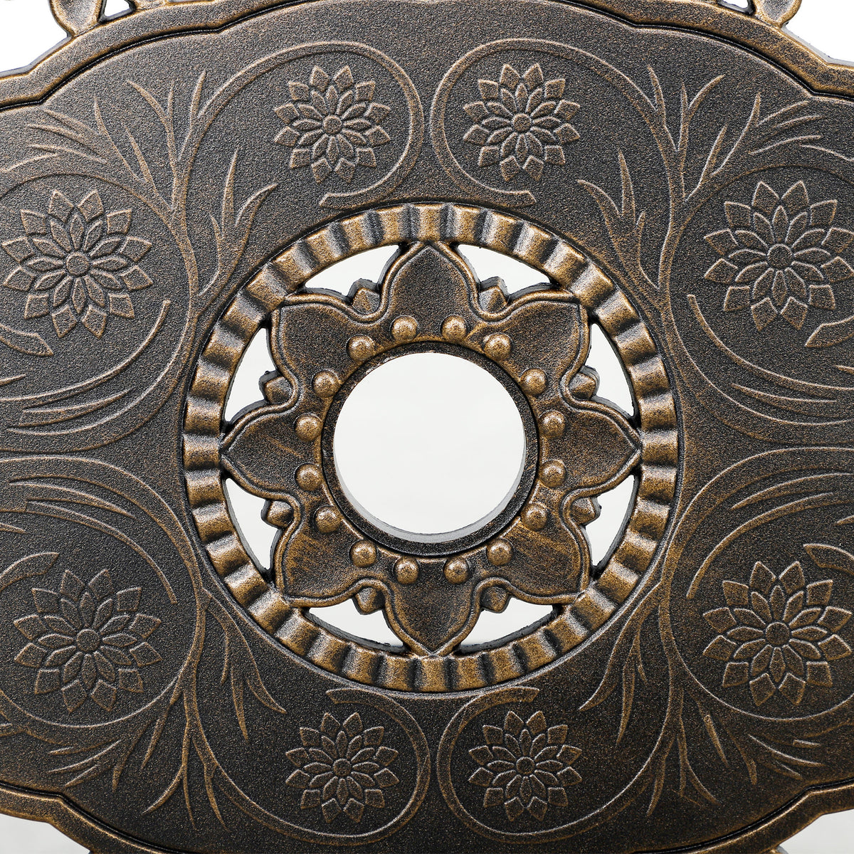 Close-up of floral bronze-tone table pattern surrounding the parasol hole