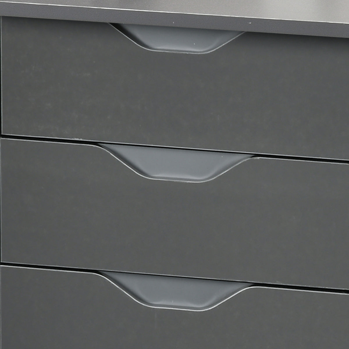 Close-up of three grey desk drawers with recessed groove handles.