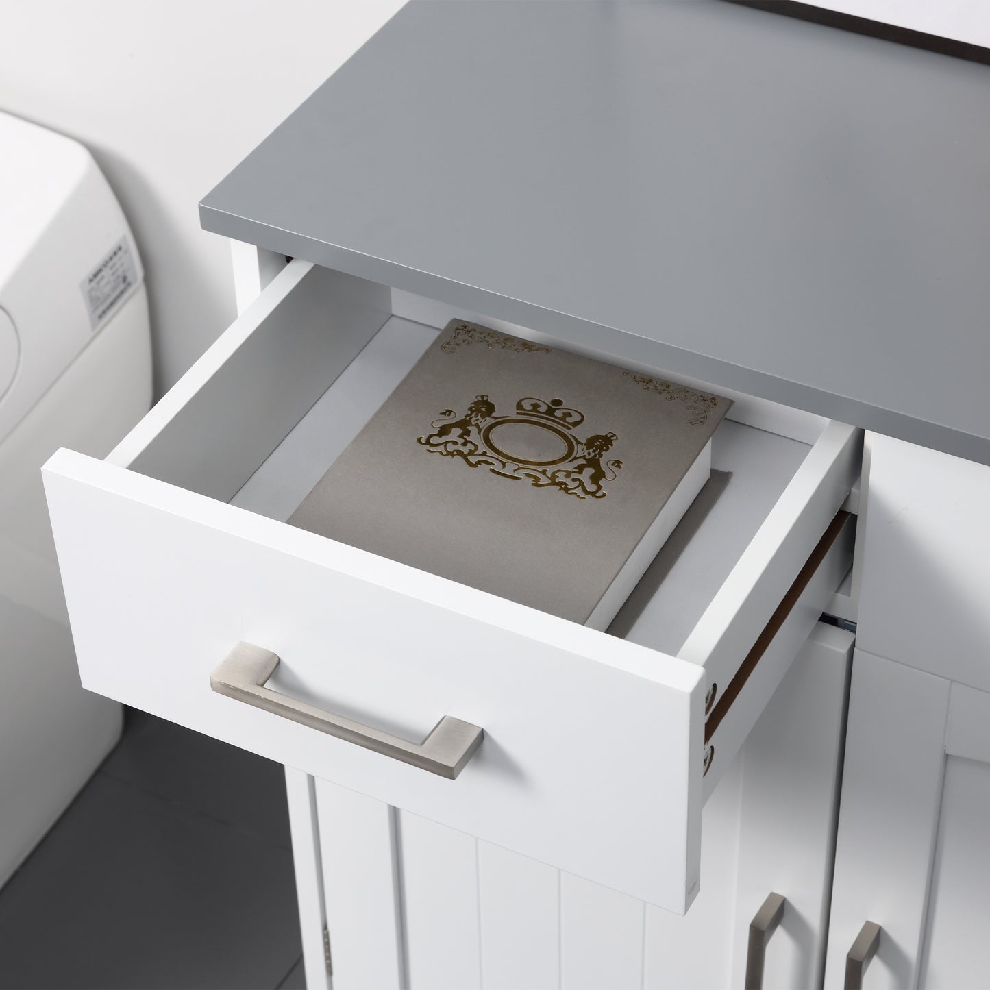 White bathroom cabinet with an open drawer and metal pull