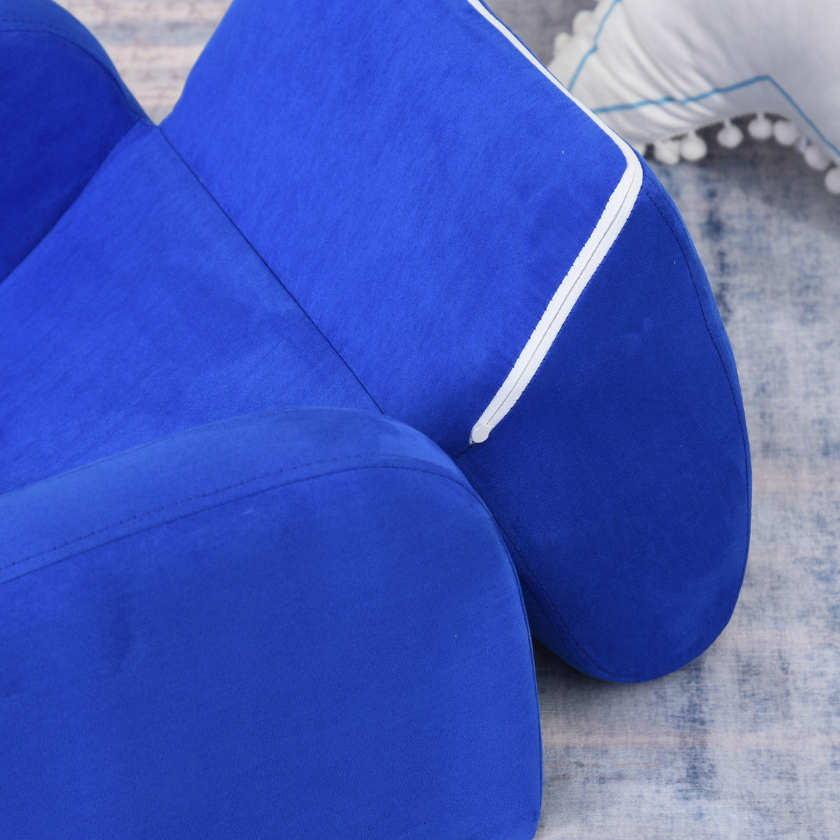 Close-up of the blue chair's padded back, armrest, and white-trimmed fold-out panel.