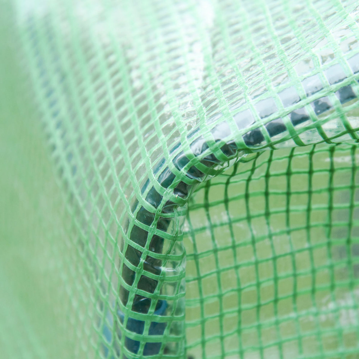 Close-up of the greenhouse's reinforced green mesh cover seam