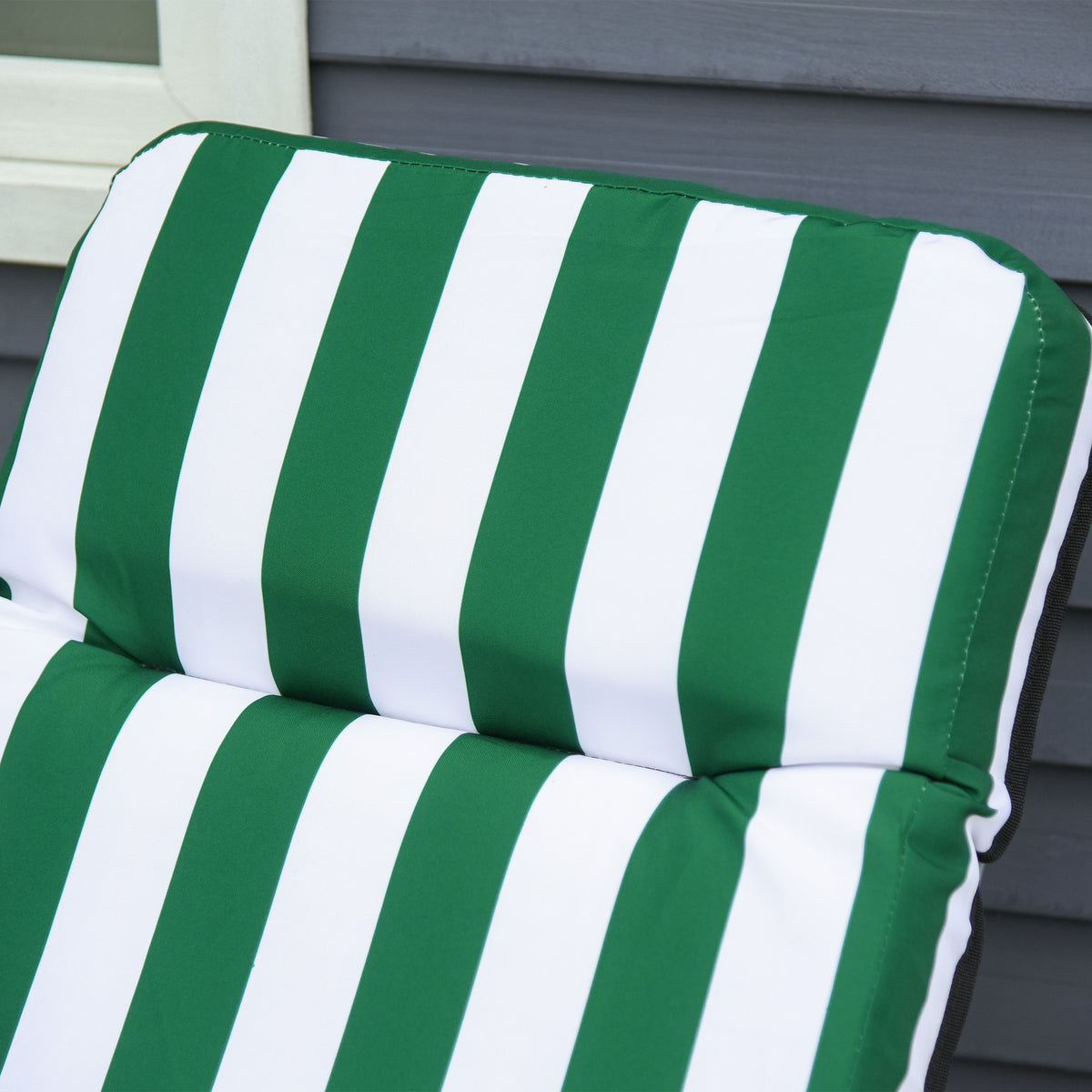 Close-up of the green and white striped padded backrest on a sun lounger