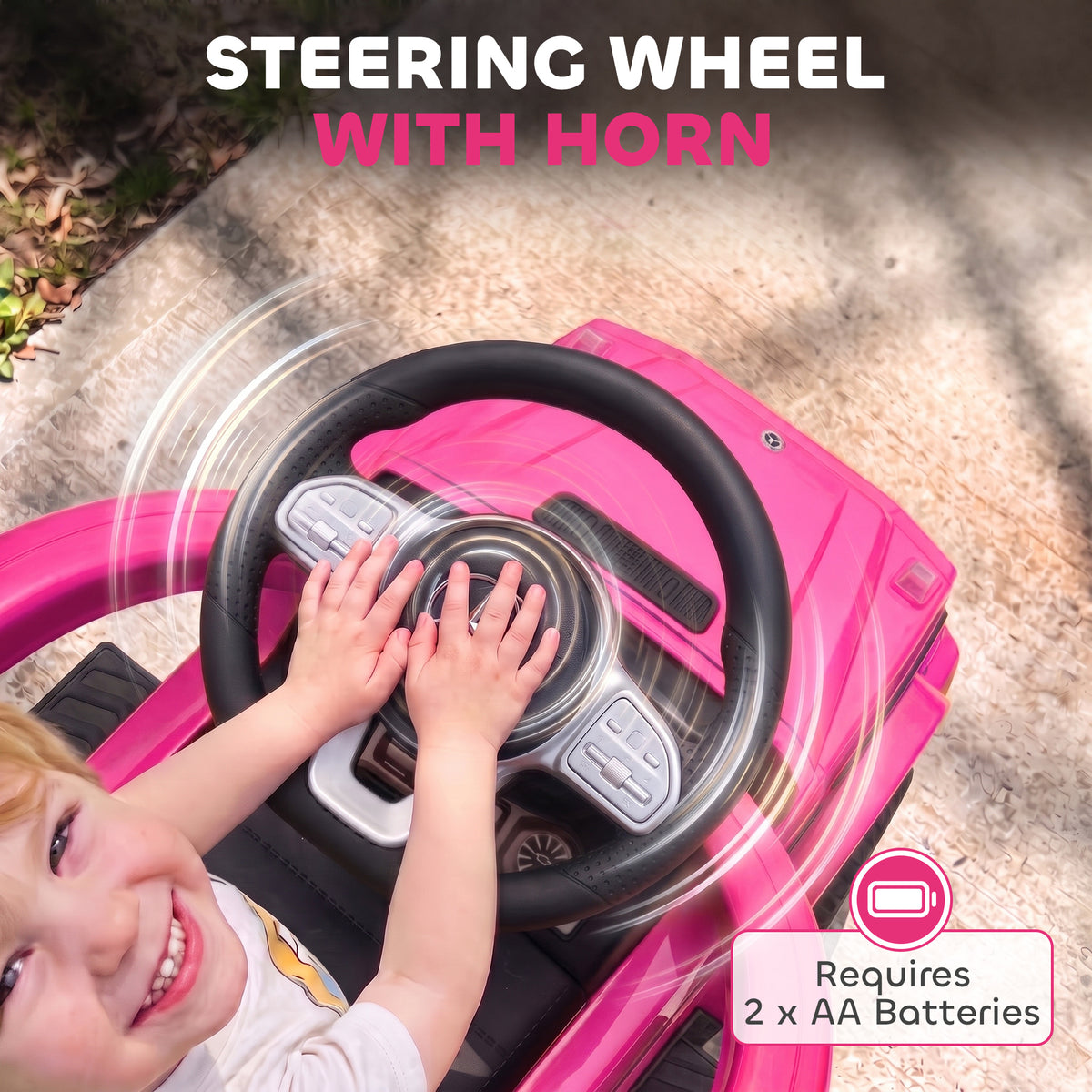 Pink ride-on car steering wheel with horn, operated by a child