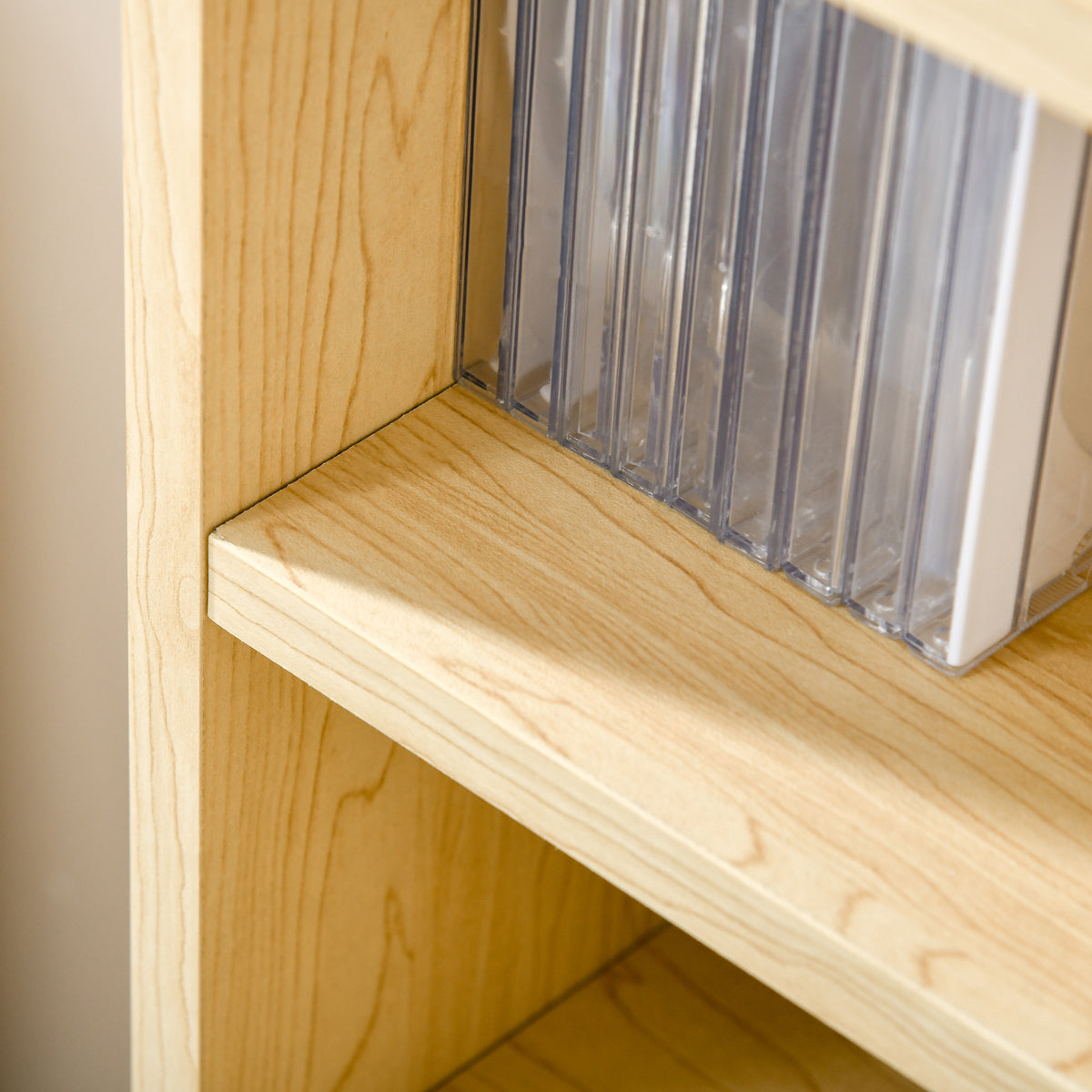 Close-up of oak-tone shelf showing wood grain and a CD case
