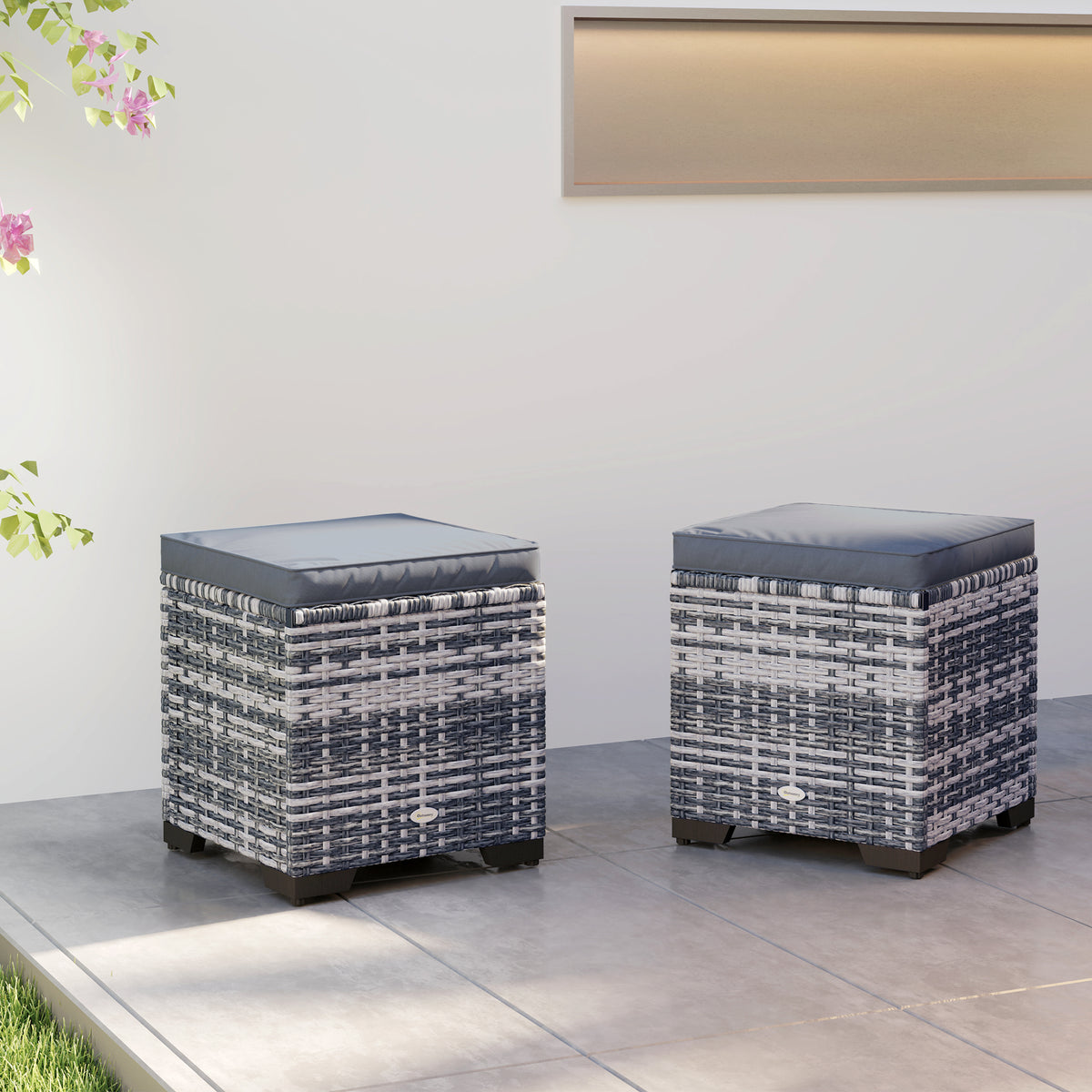 Two dark gray rattan ottomans with square padded cushions
