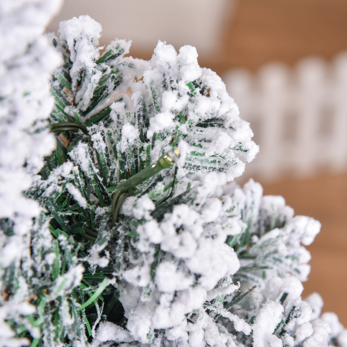 Close-up of green artificial tree branches coated in white flocking