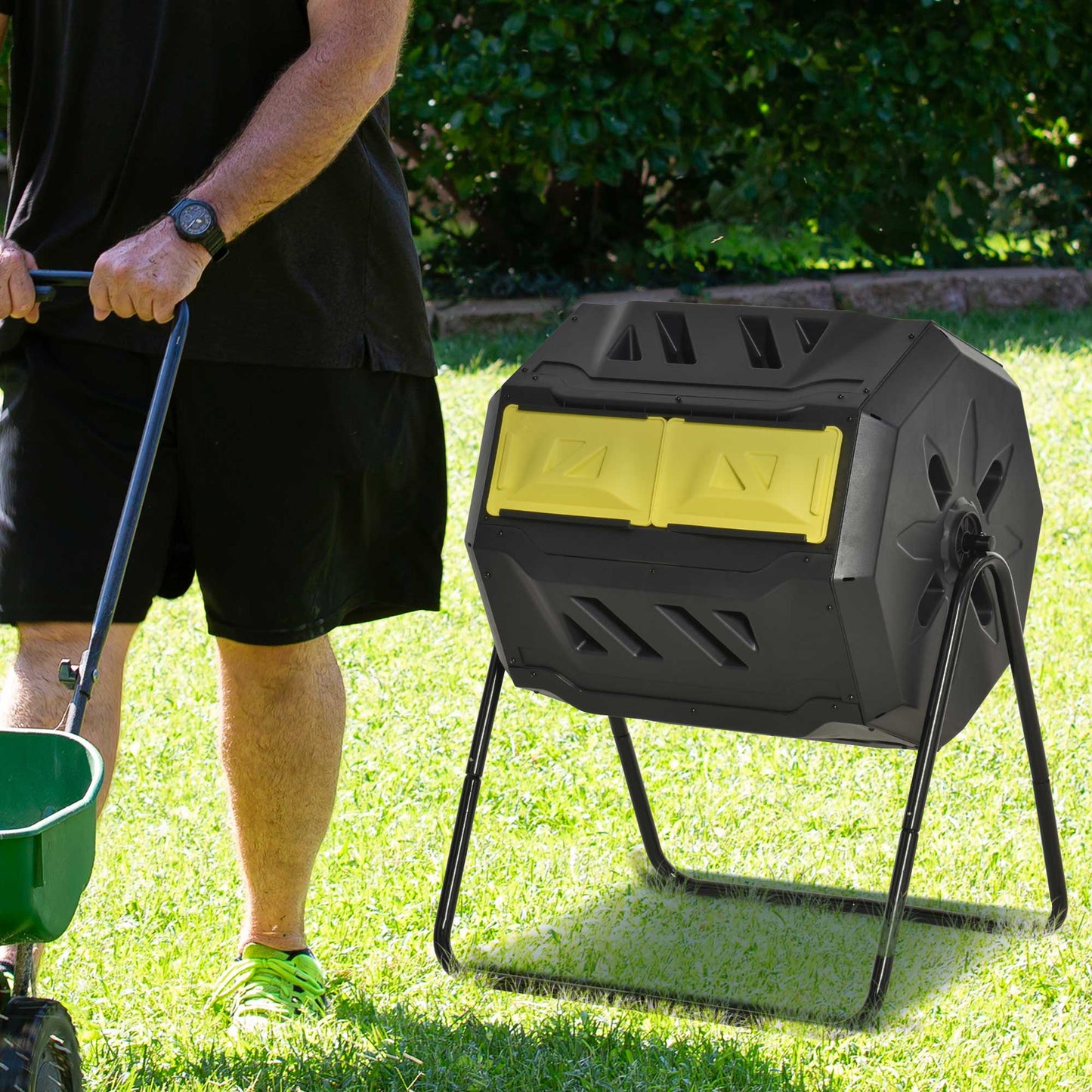 Outsunny black and yellow rotating composter on a steel stand beside a person.