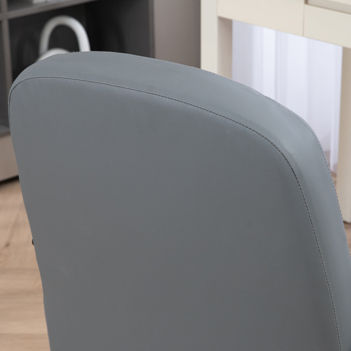 Grey PU leather office chair backrest close-up with stitched edging