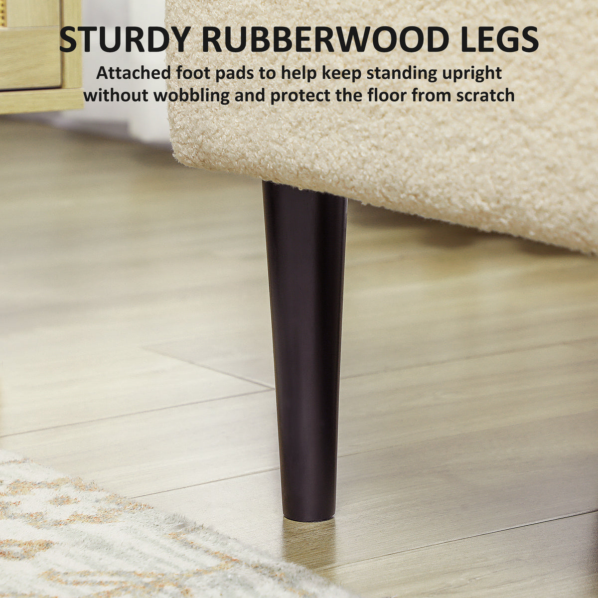 Close-up of a black rubberwood ottoman leg beneath cream teddy fleece upholstery