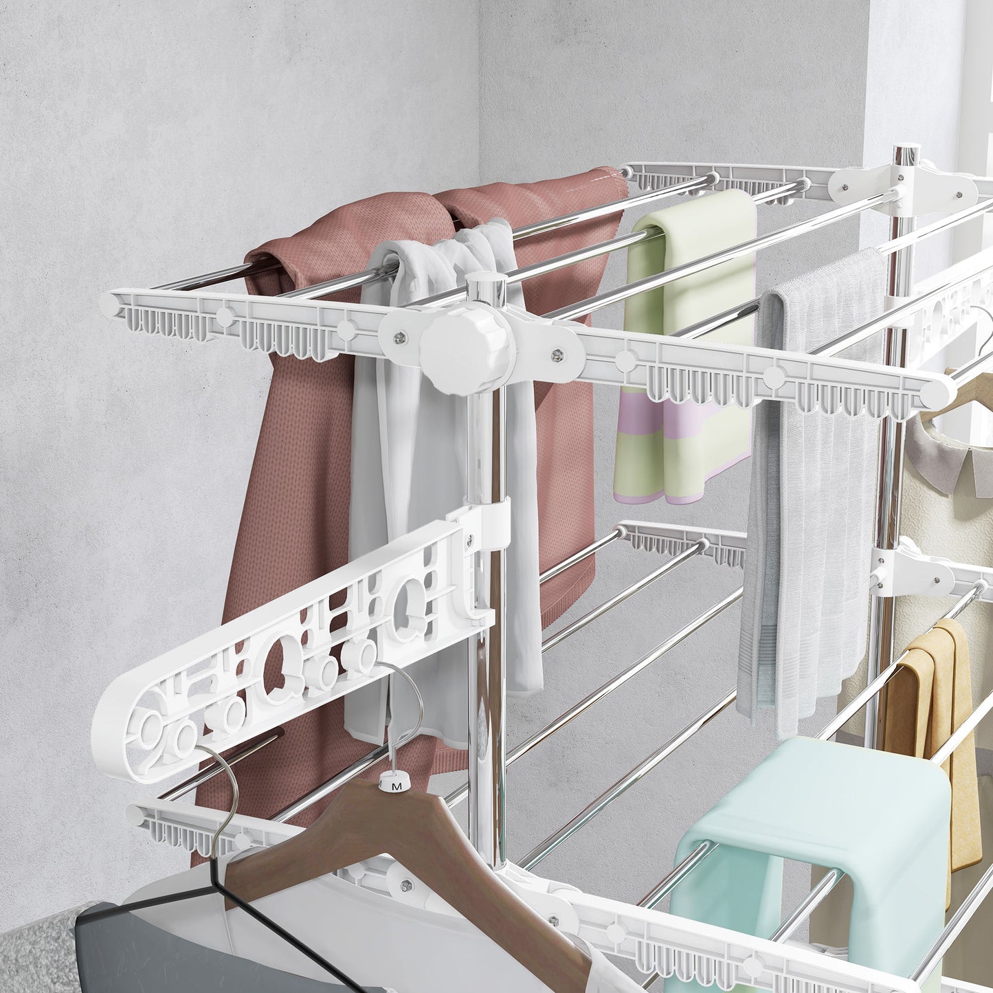 Close-up of white four-tier drying rack rails and side arms holding garments on hangers.