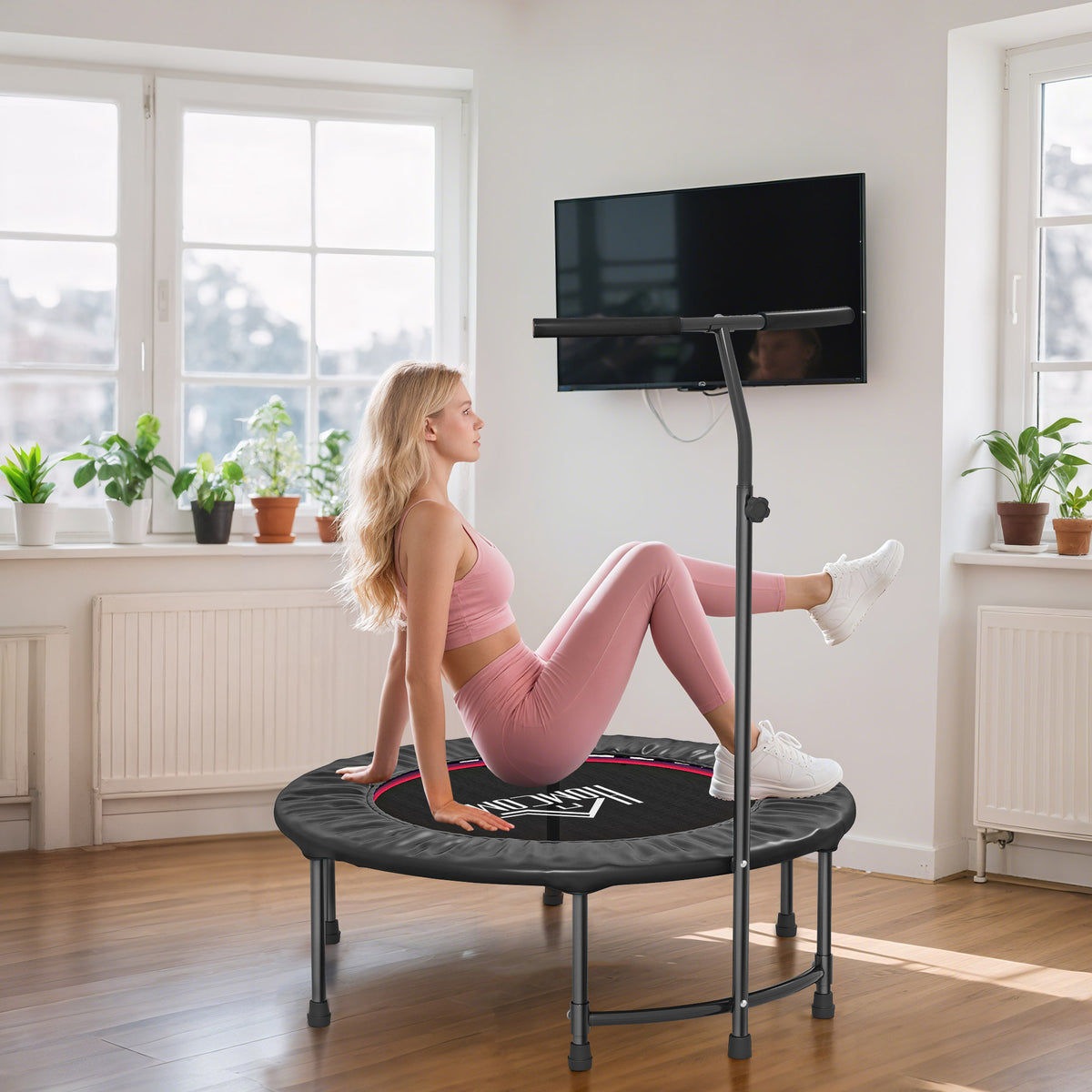 Black mini fitness trampoline with support handle and padded jumping surface