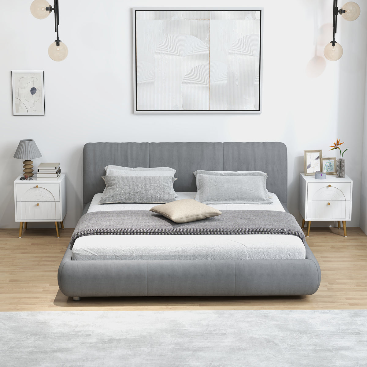 Pair of white bedside tables with two drawers, gold knobs, and tapered legs beside a bed