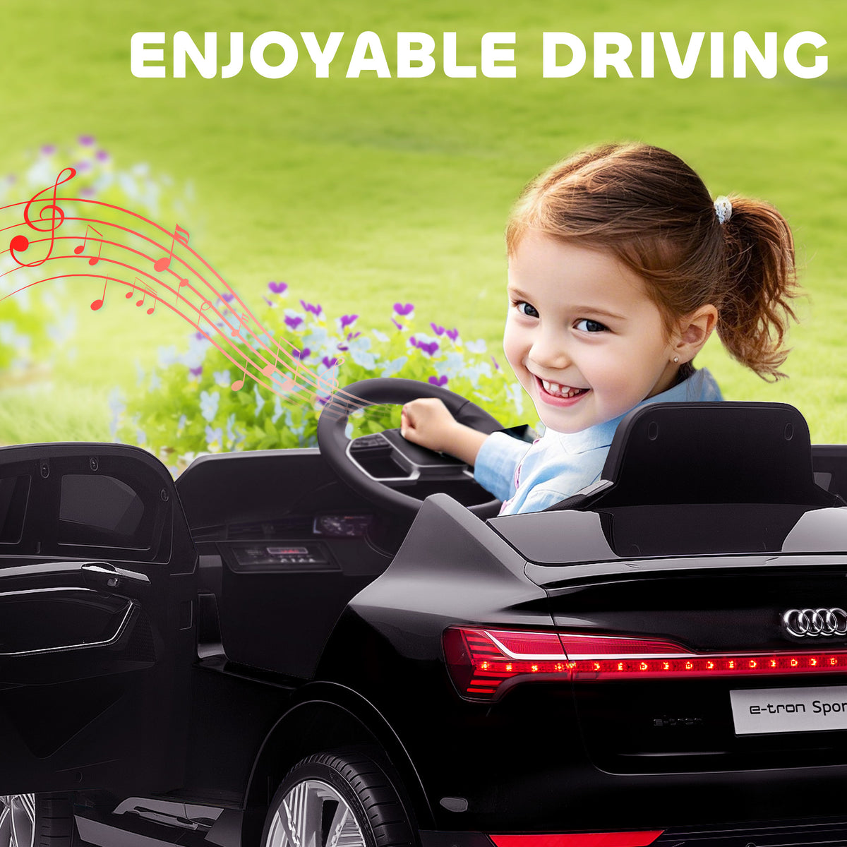 Black Audi e-tron kids' ride-on car cockpit and steering wheel with music-note graphics.