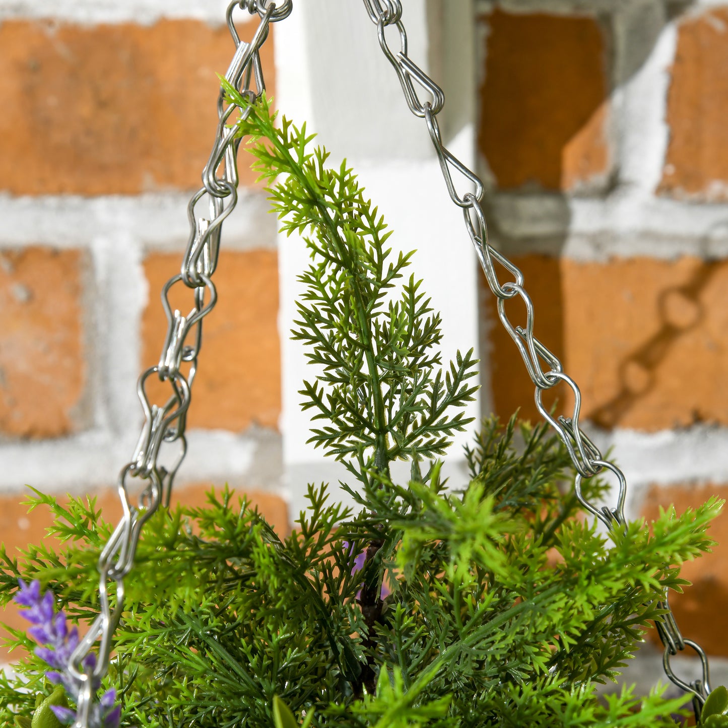 Close-up of artificial green foliage and purple lavender flowers with hanging metal chains