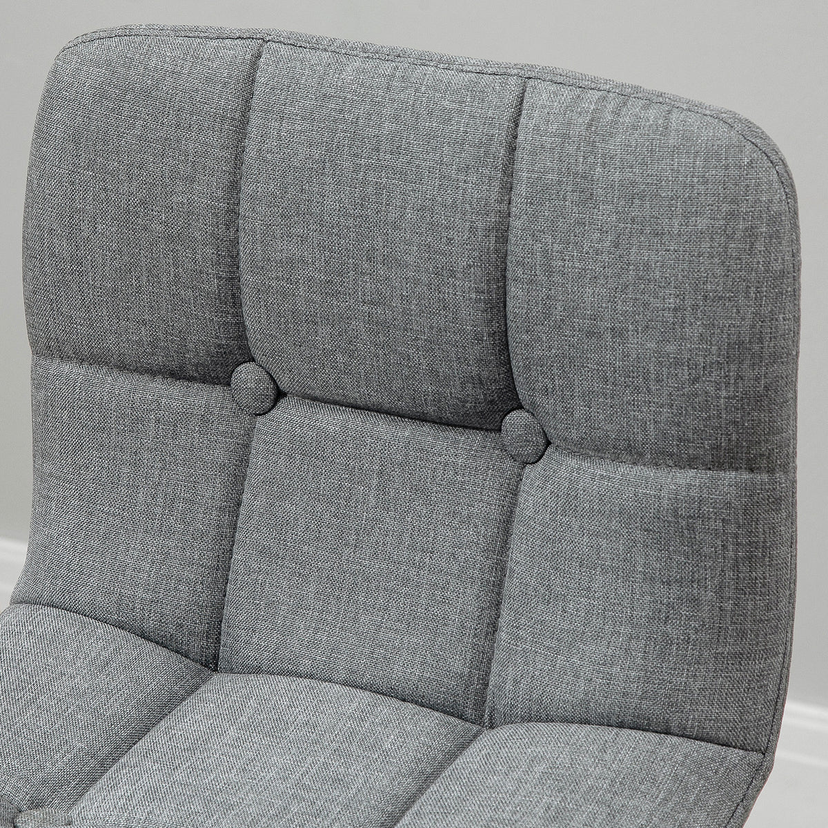 Close-up of gray textured upholstery and button-tufted backrest on a bar stool