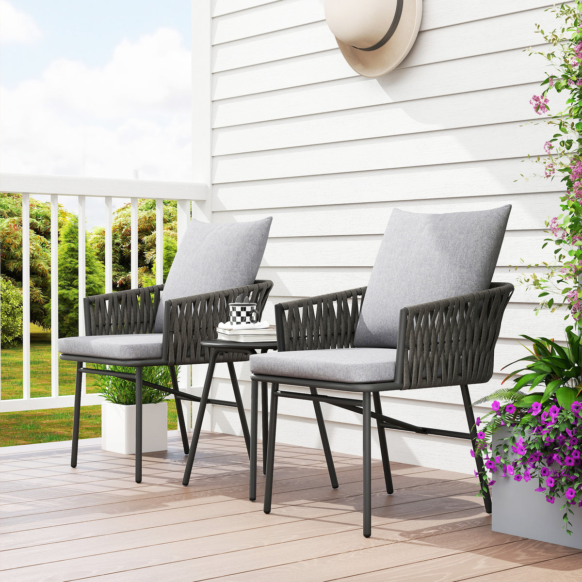 Grey rattan bistro set arranged with two cushioned chairs and table