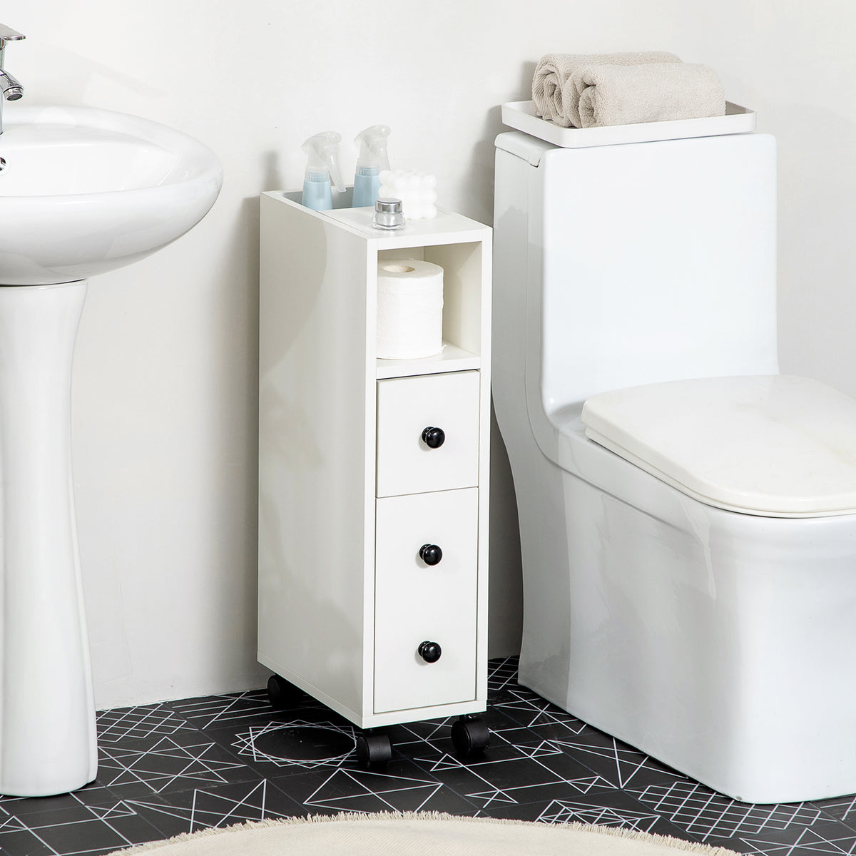 Slim white bathroom storage cabinet beside a toilet, with an open shelf, drawers and caster wheels