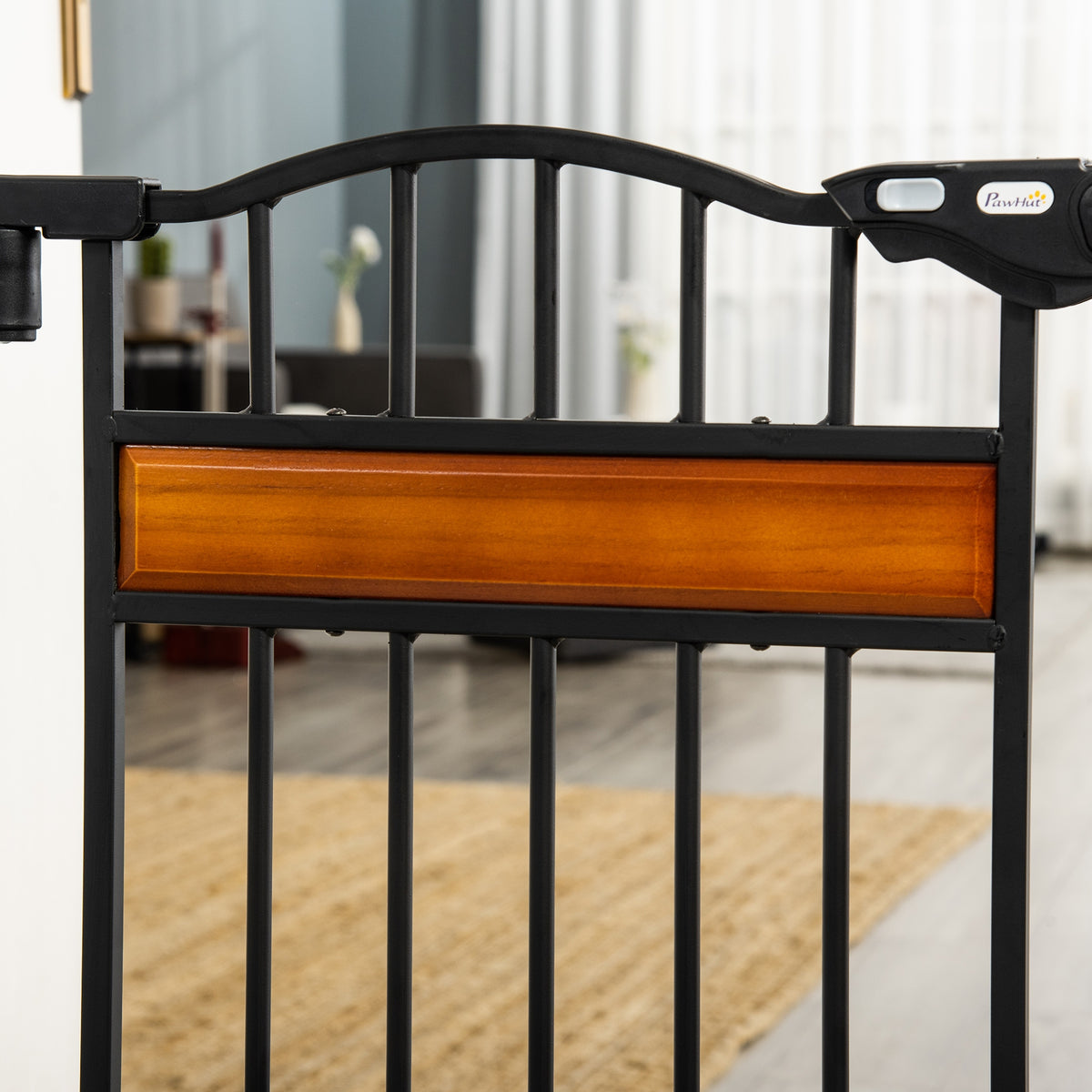 Black metal pet gate detail with a wood-tone center panel and arched top rail