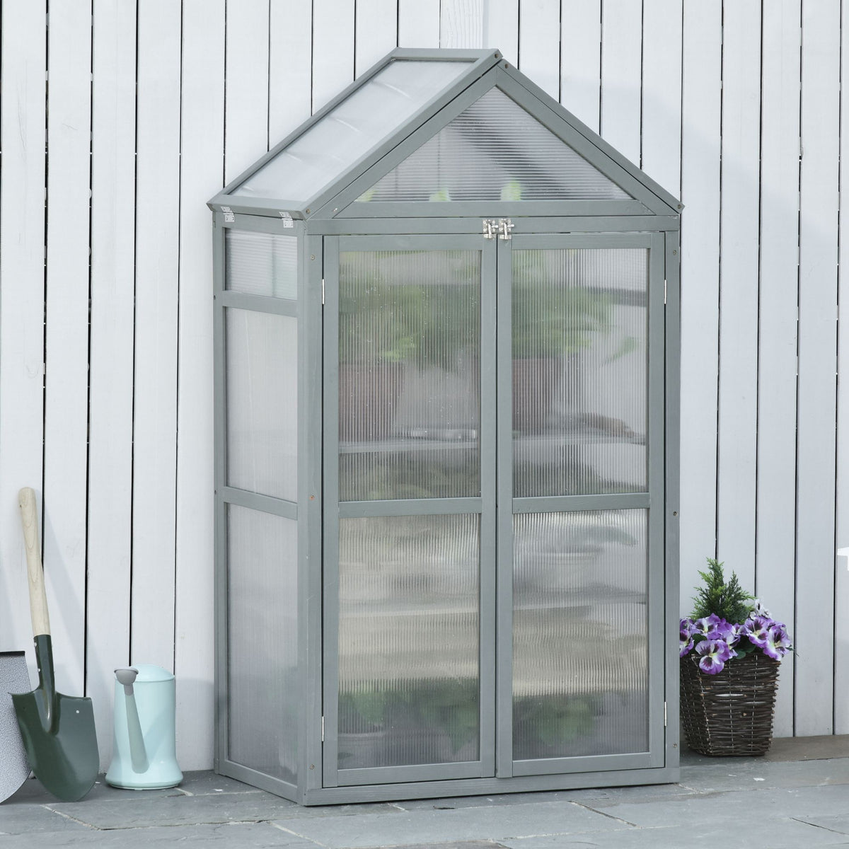 Grey polycarbonate greenhouse with peaked roof, double doors and visible interior shelves