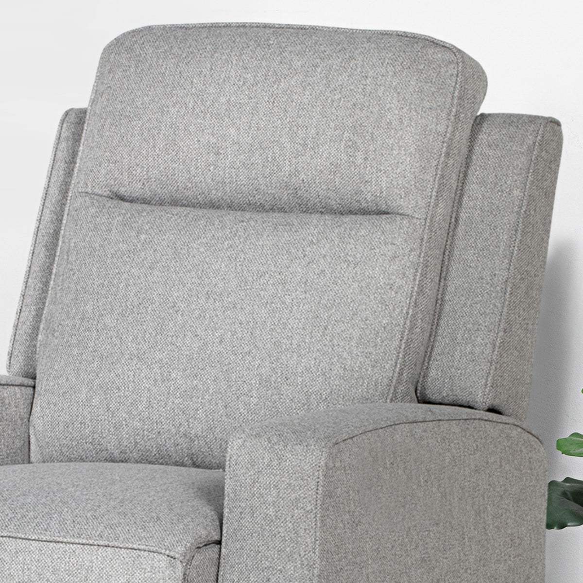 Close-up of the grey recliner's padded back, seat, and armrest
