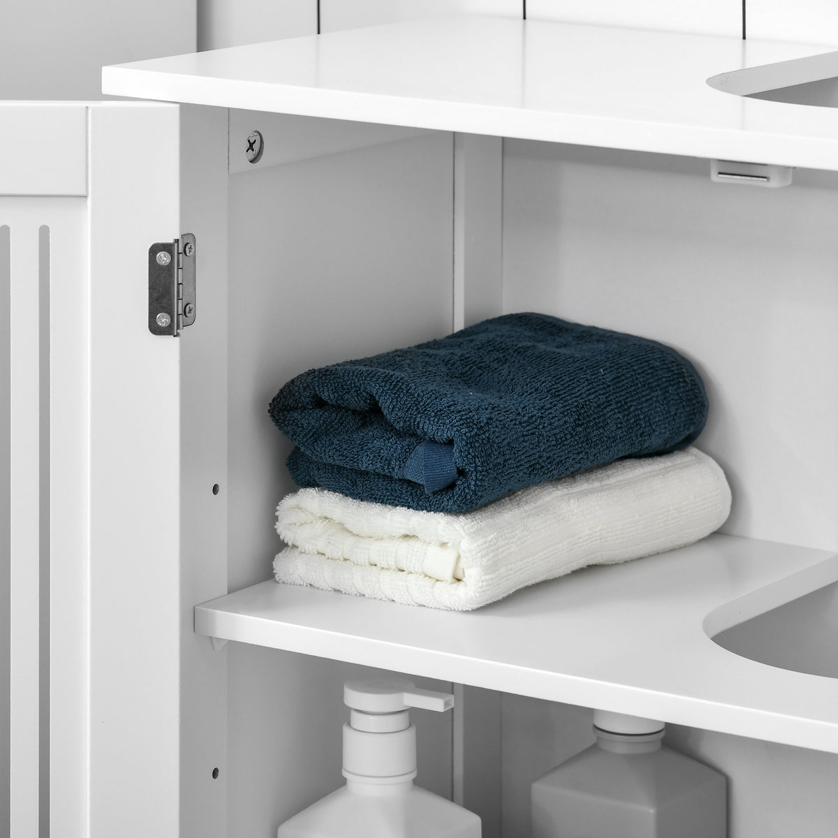Under-sink cabinet interior shelf with towels and plumbing clearance