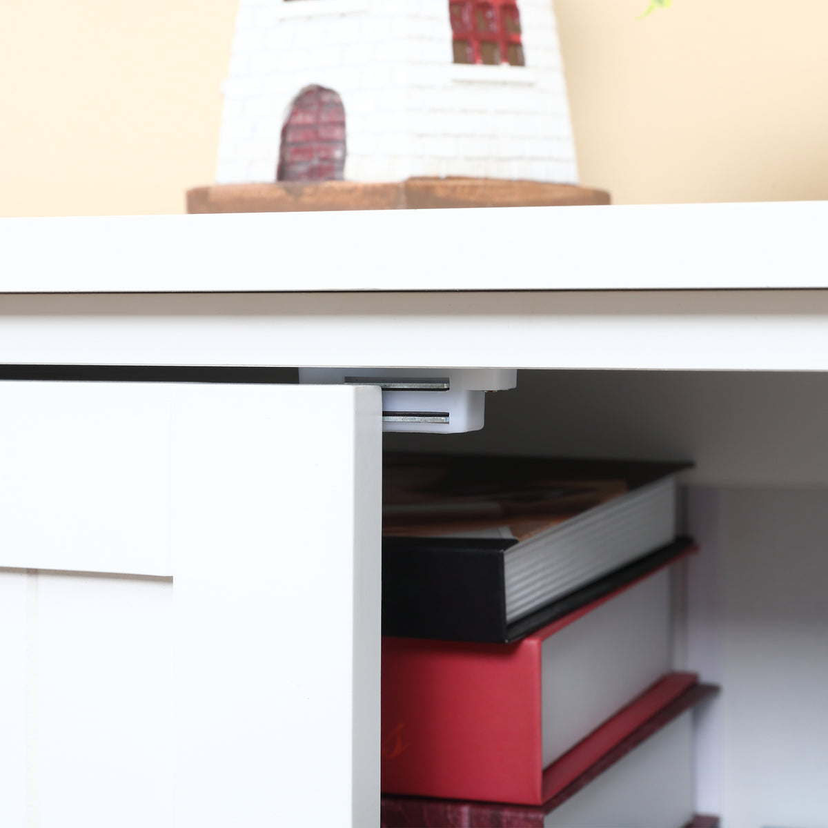 Close-up of a white cabinet door and its concealed top-mounted metal snap.