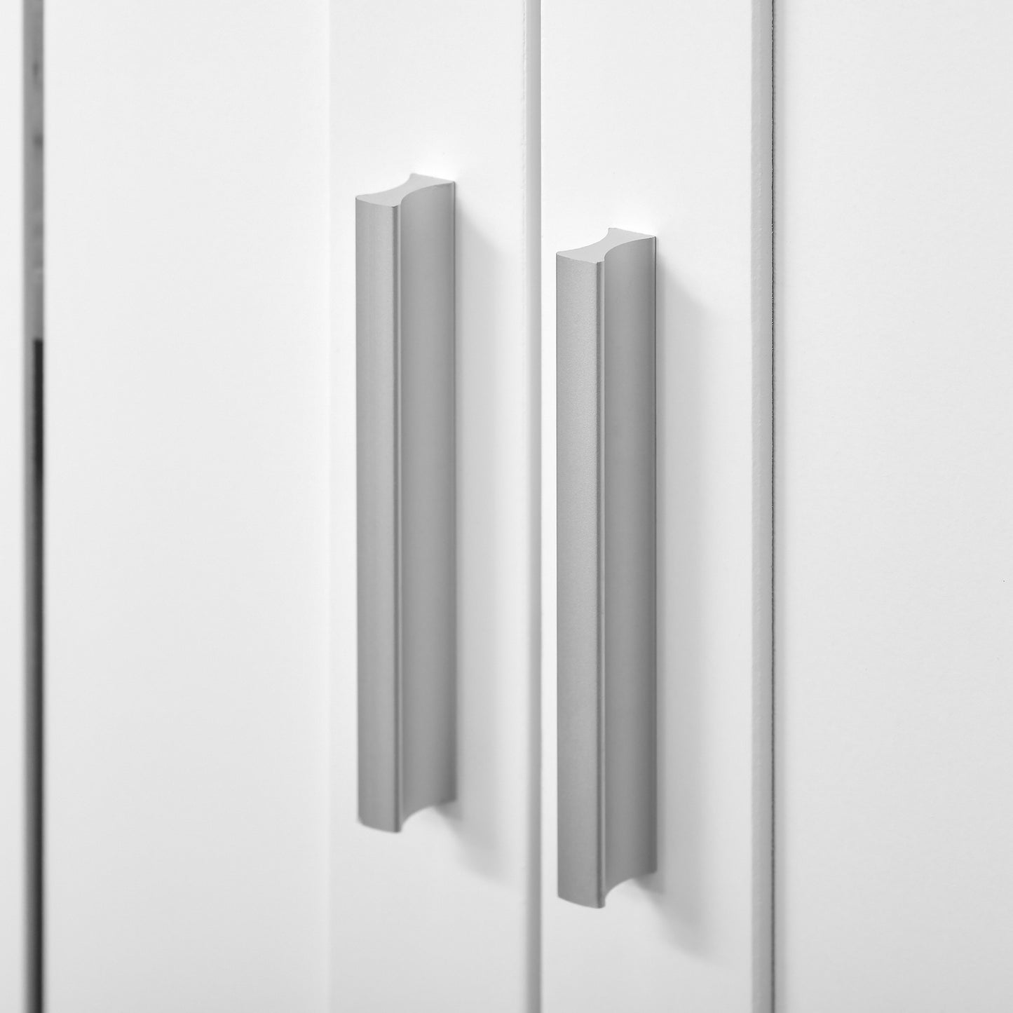 Close-up of two silver handles on the white cabinet doors