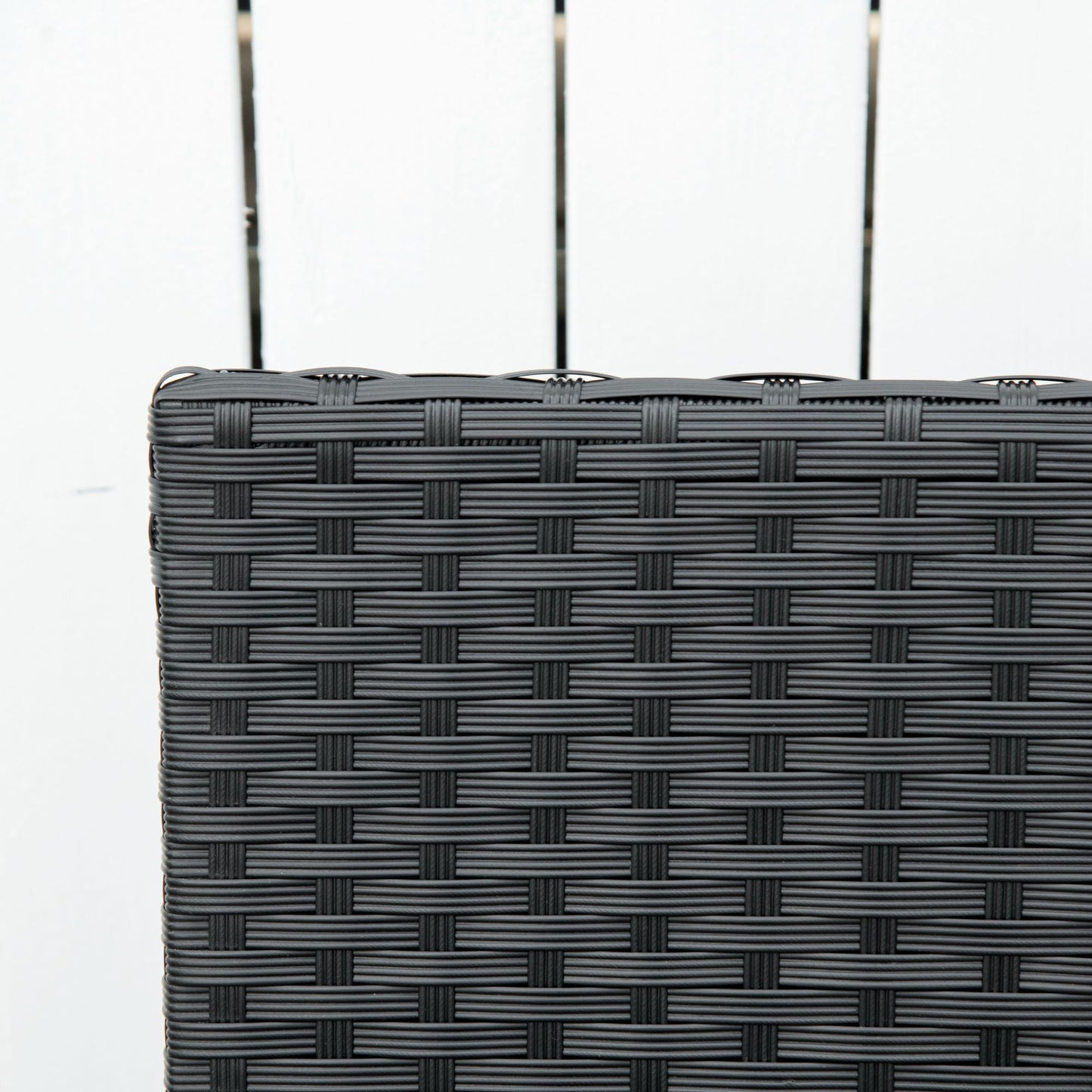 Close-up of the black rattan weave along the bench backrest