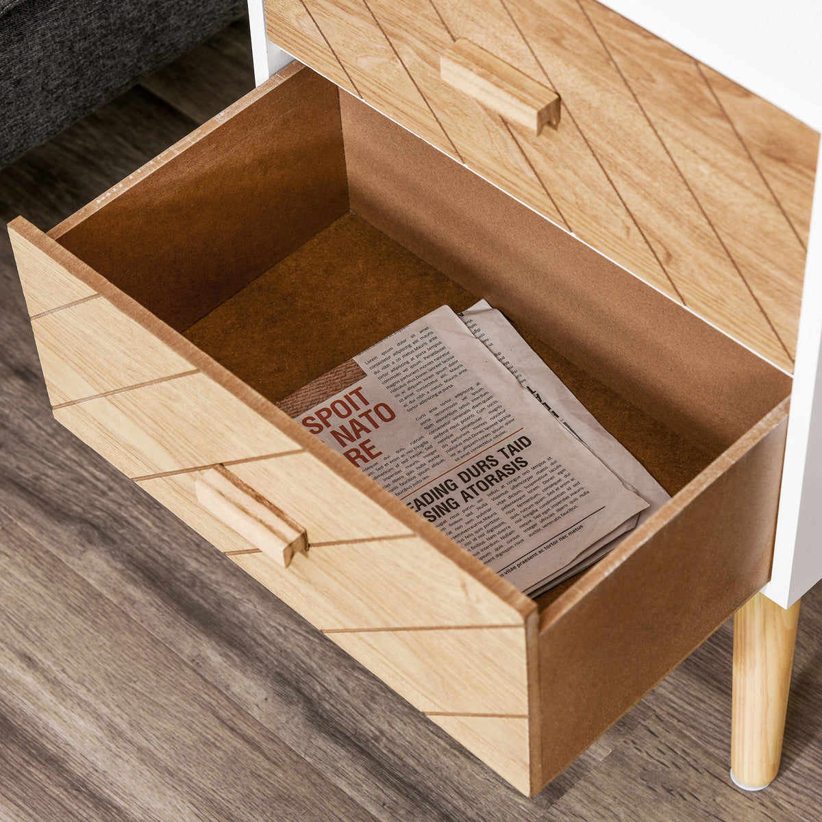 Open bedside table drawer showing the wood-patterned front and roomy interior