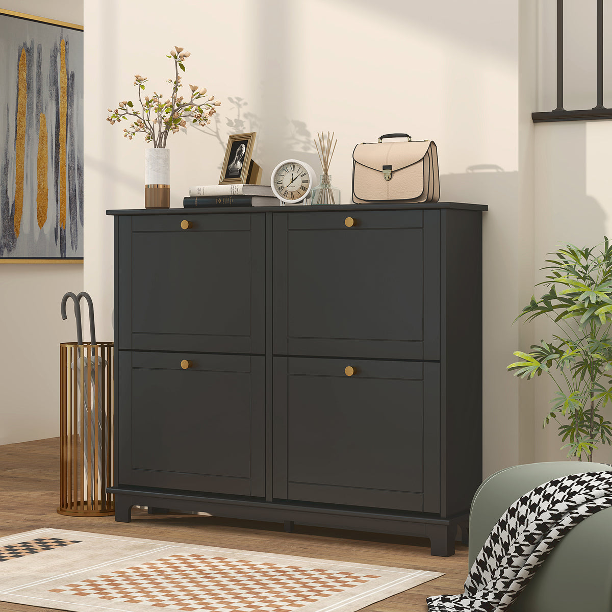 Black shoe cabinet with four closed flip drawers and gold knobs.