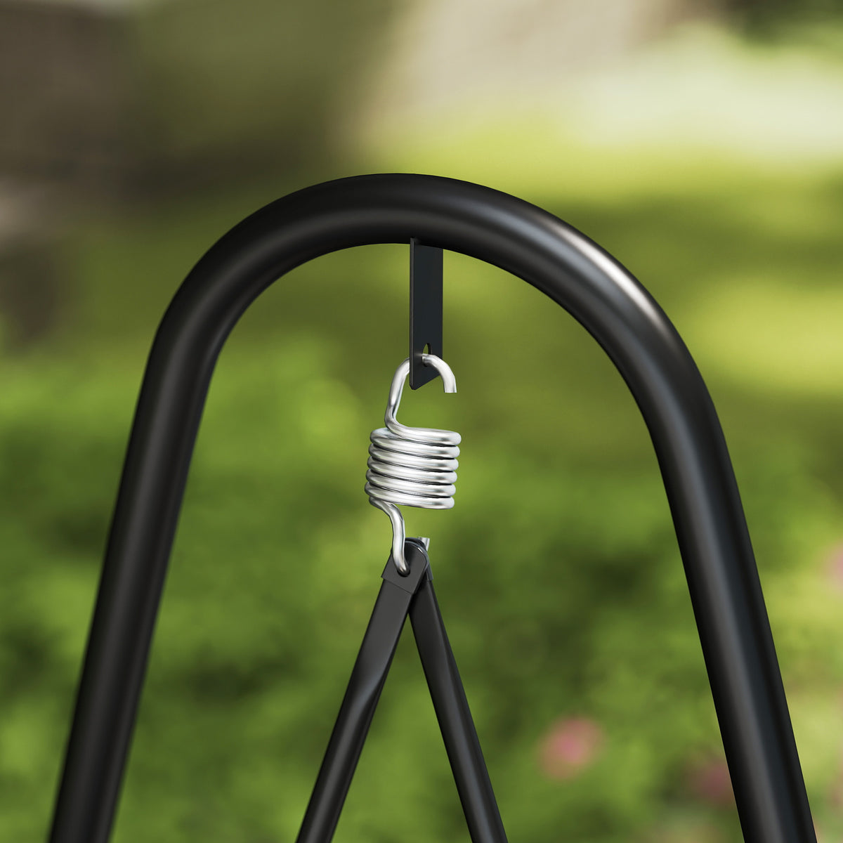 Close-up of the swing chair's suspension spring and black steel frame