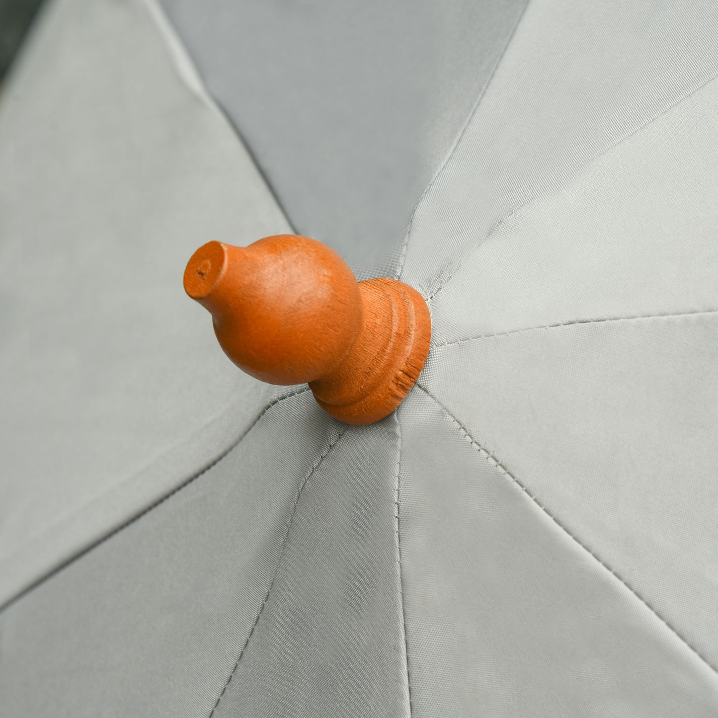 Close-up of the wooden finial and stitched grey canopy of the Outsunny parasol
