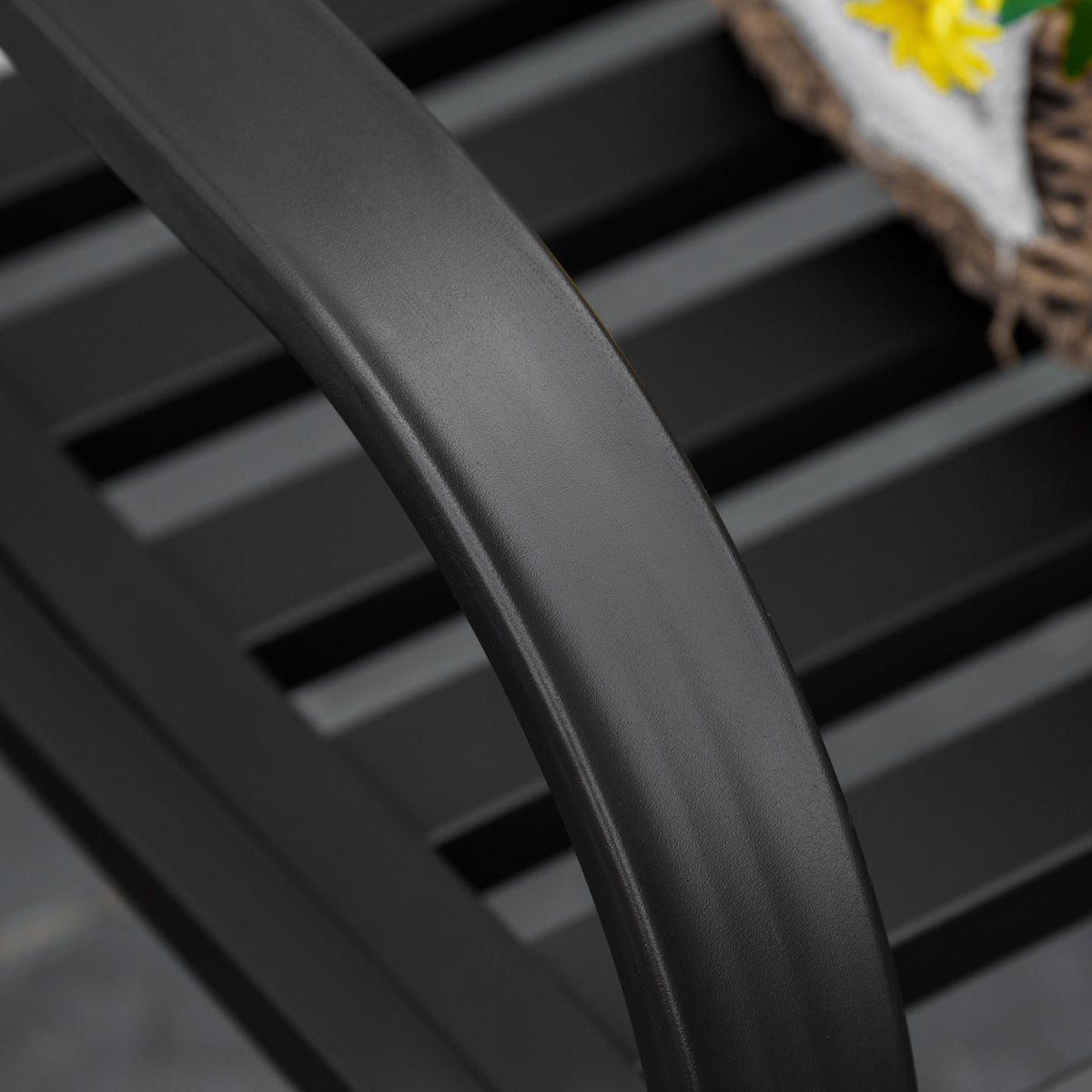 Close-up of the bench's curved arm and dark slatted seat