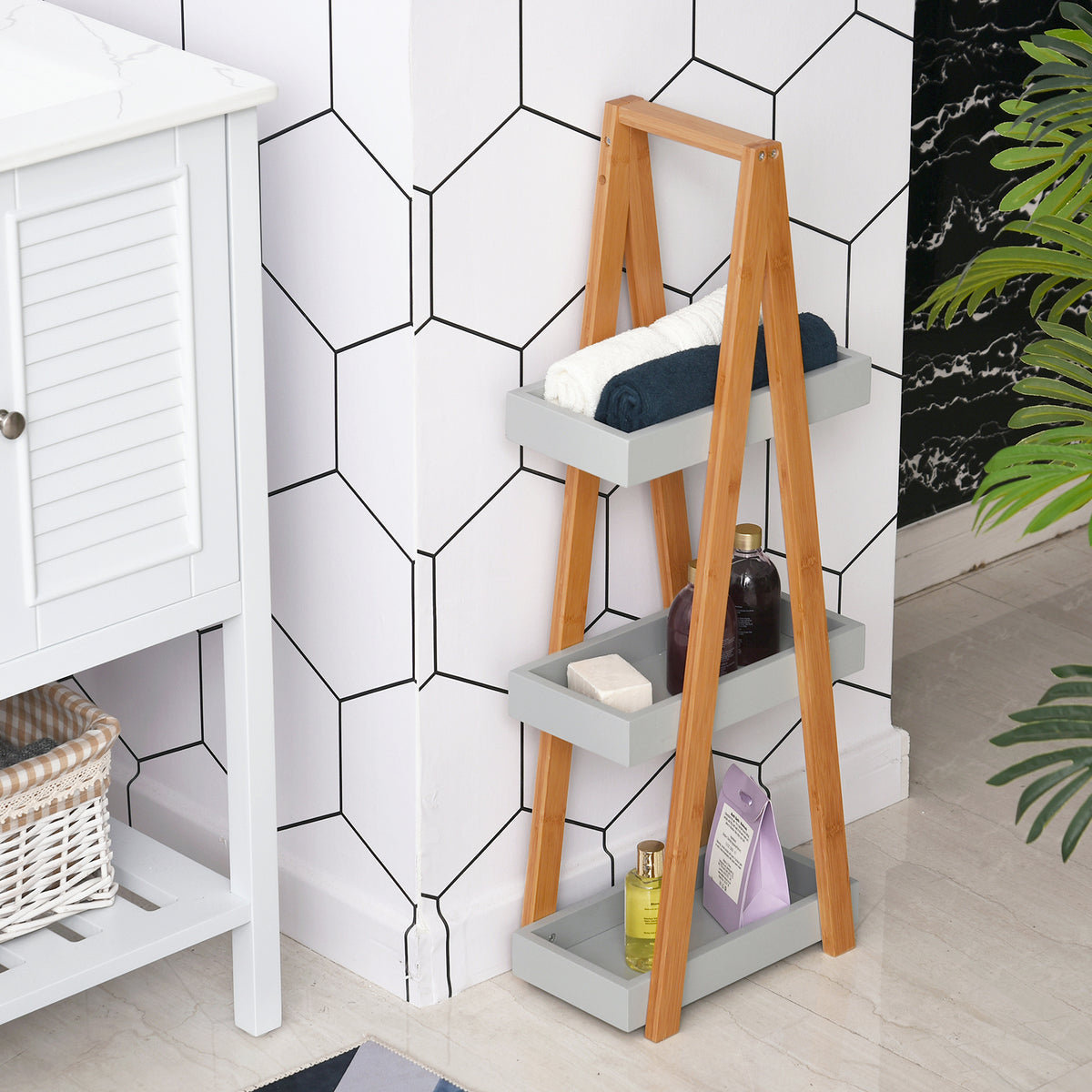 Slim three-tier bamboo shelf holding towels and bathroom products
