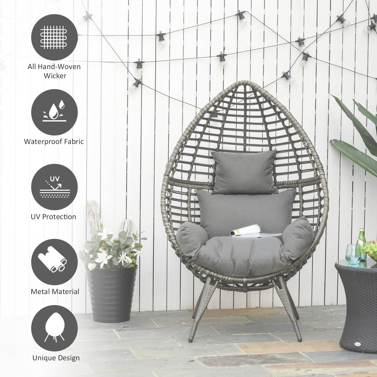Cushioned teardrop wicker chair with hand-woven frame and padded gray cushions