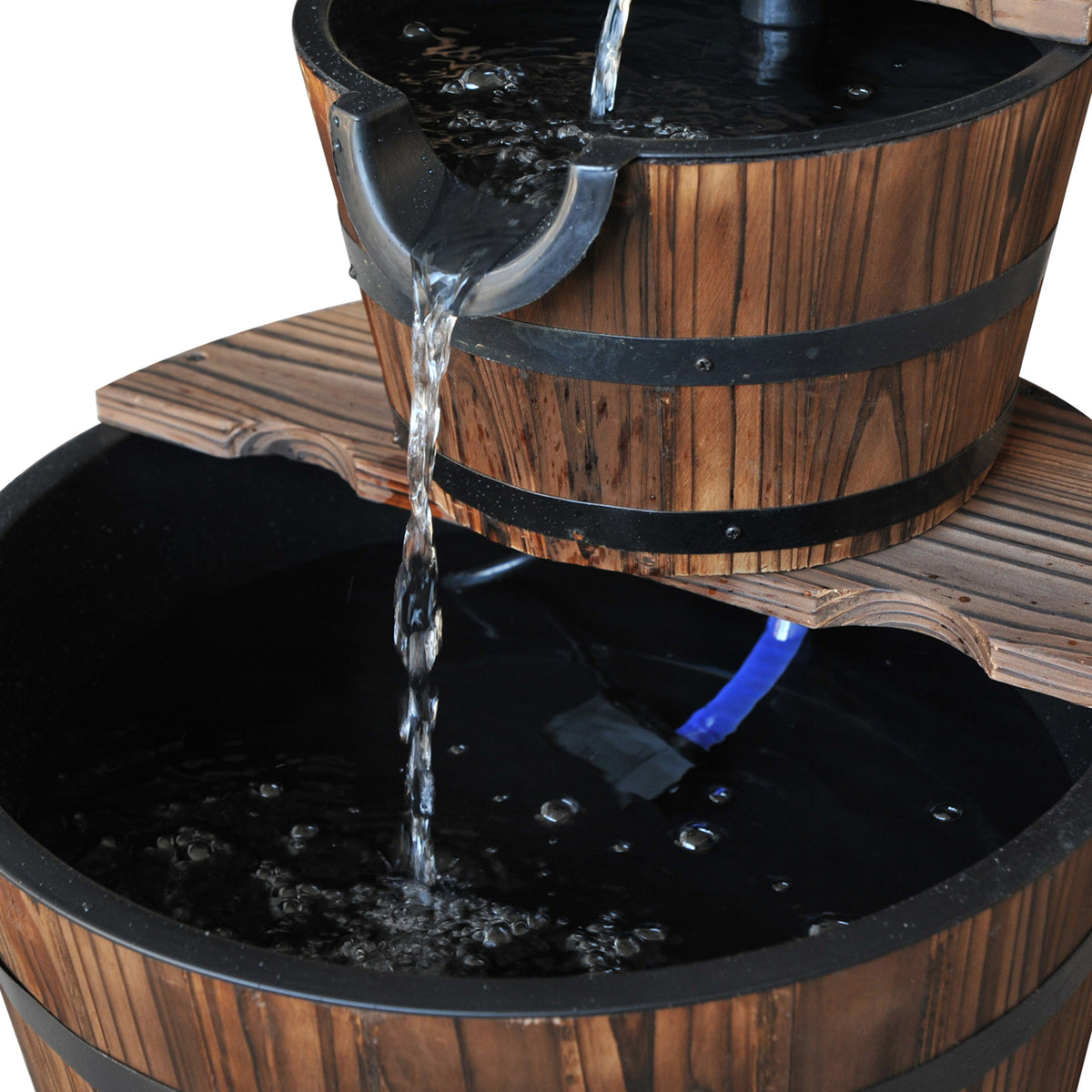 Close-up of water spilling from the upper wooden basin into the lower basin