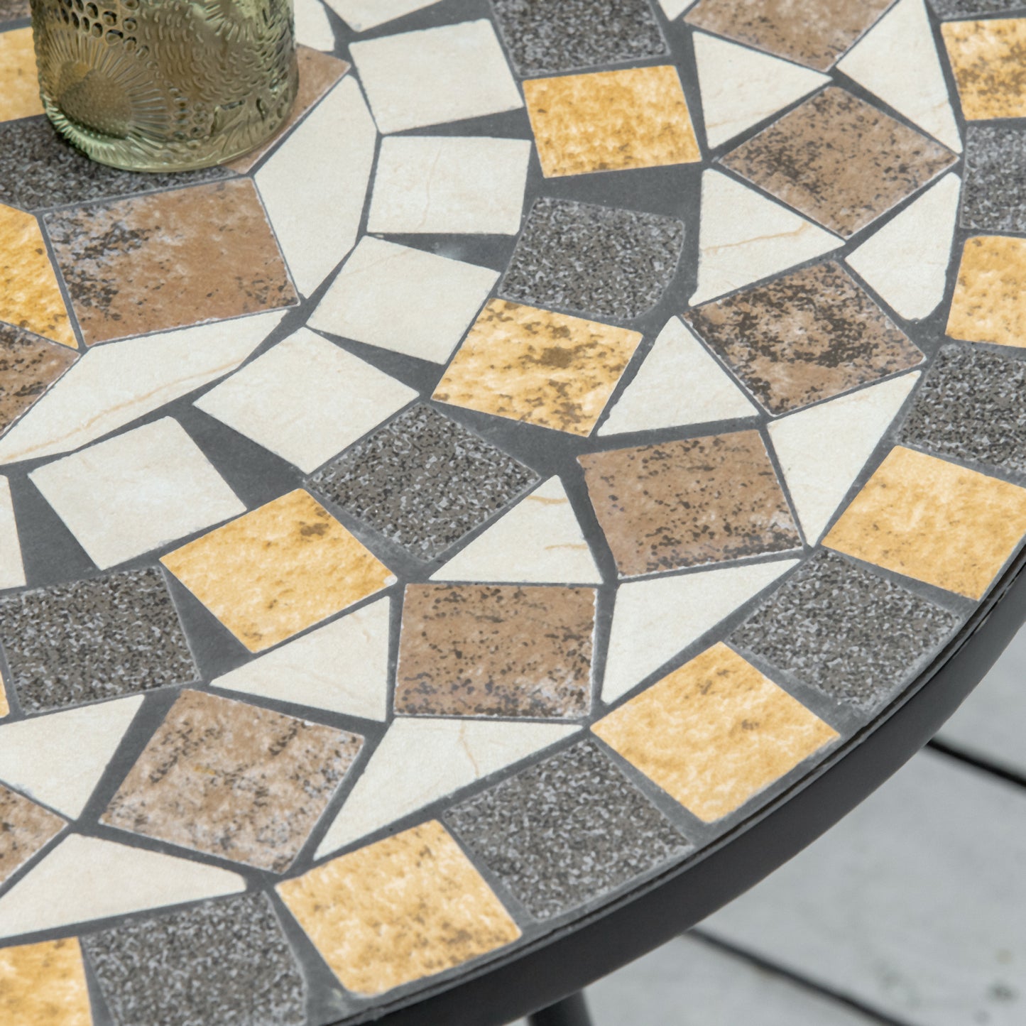 Close-up of the table's ceramic mosaic top with cream, gray, brown, and ochre tiles