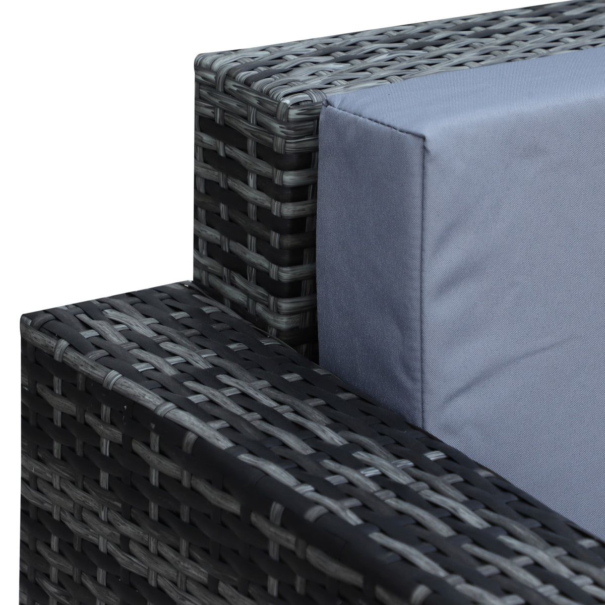 Grey rattan sofa arm and woven frame with a grey cushion in close-up.