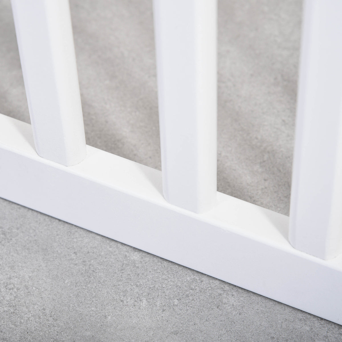 Close-up of white wooden gate slats and lower rail