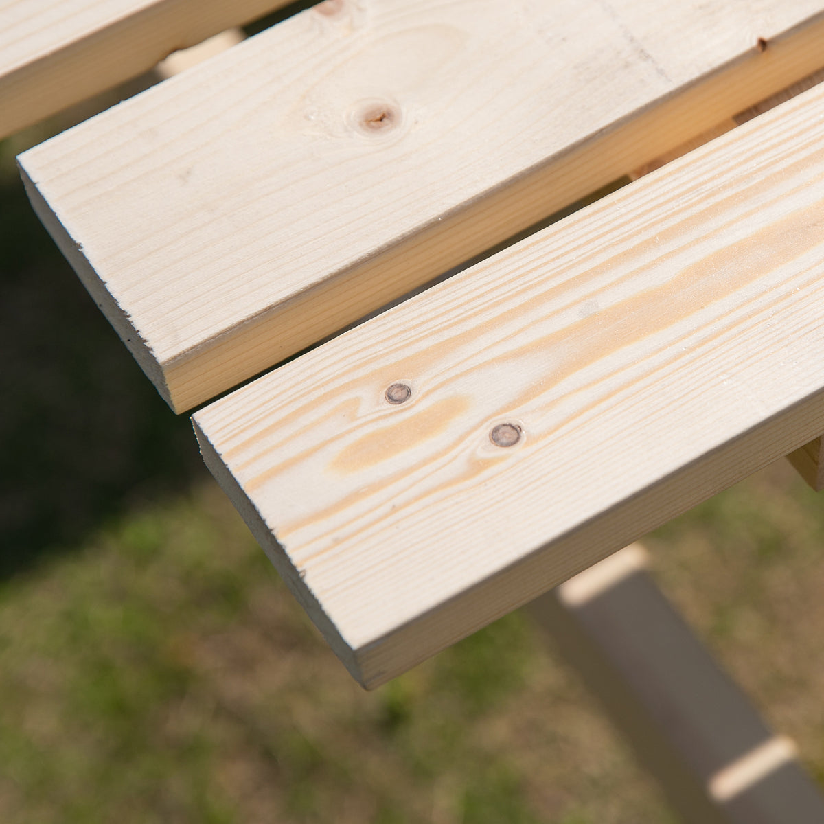 Close-up of natural wood slats on the picnic table bench