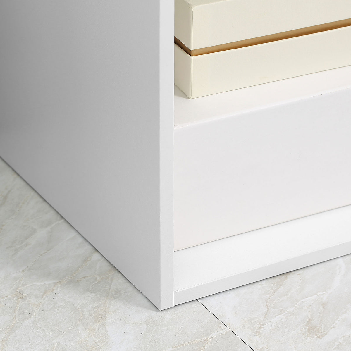 Close-up of the white bookcase side panel, shelf, and base