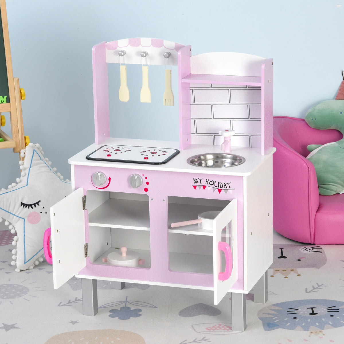 Pink kids' play kitchen with open cabinets, stove, sink, oven, and hanging utensils