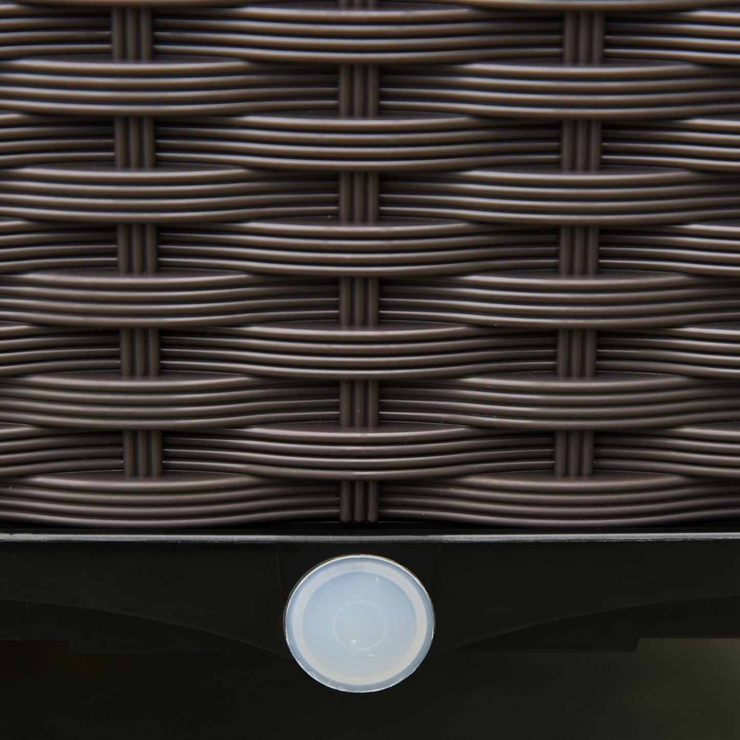 Close-up of the brown woven planter side and circular drainage hole.